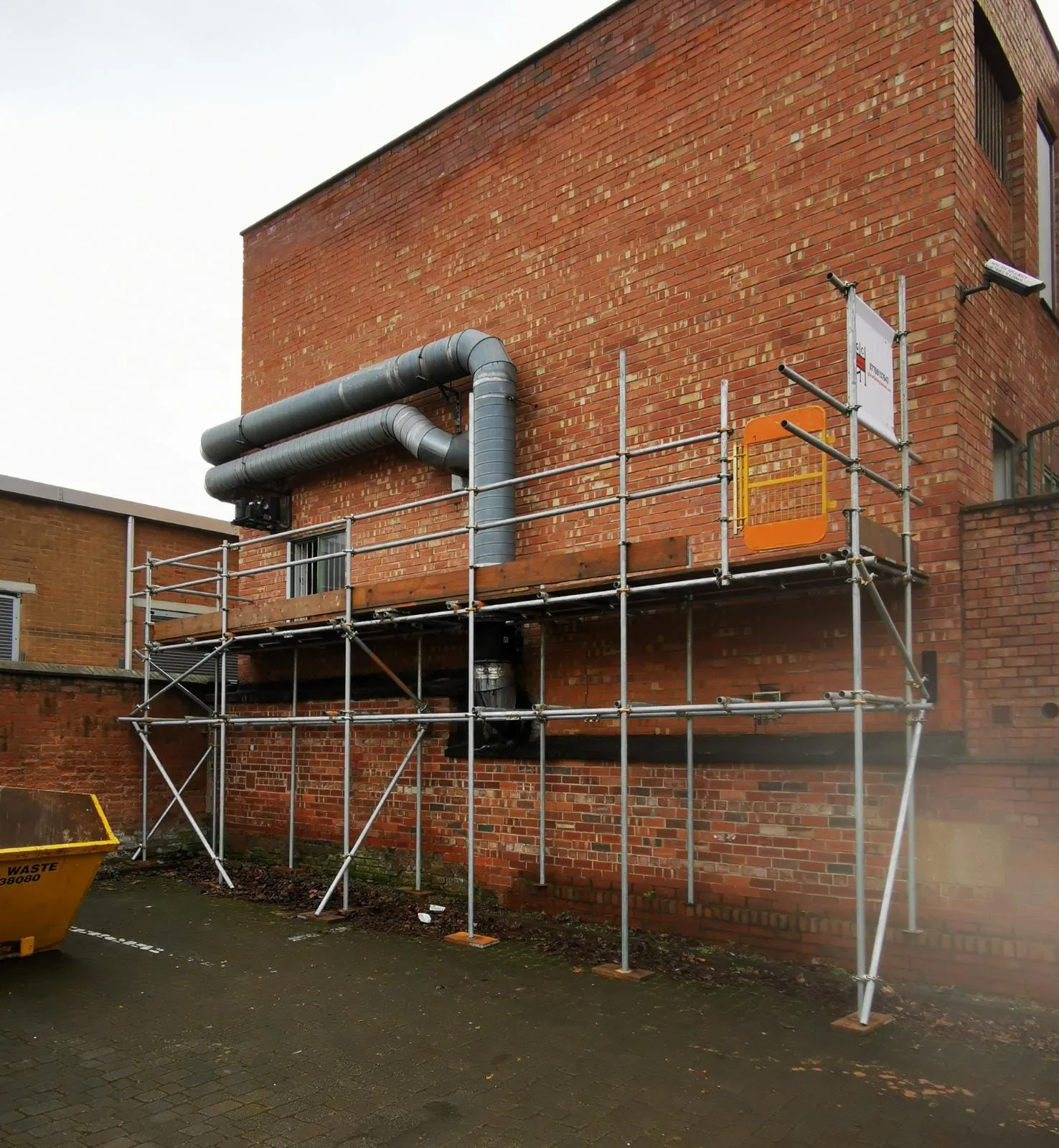 Two-lift scaffold providing access to ductwork on the side of a brick industrial building