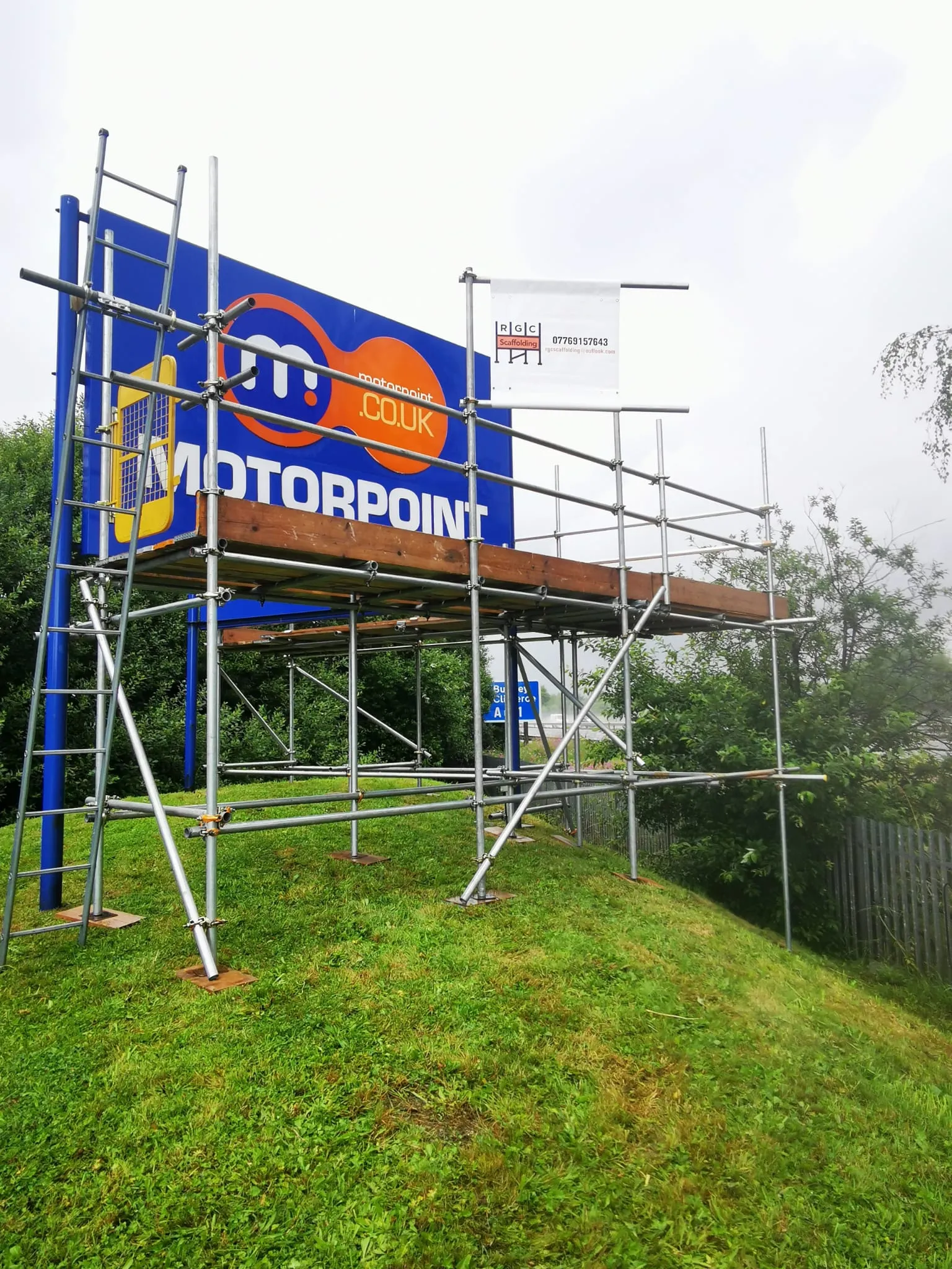 Free-standing access scaffold and platform erected around a large roadside advertising sign